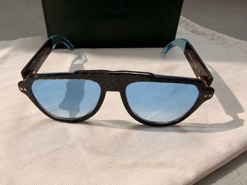 Front YerryNow One z niebieskimi szkłami UV400 na tle pudełka YouNick