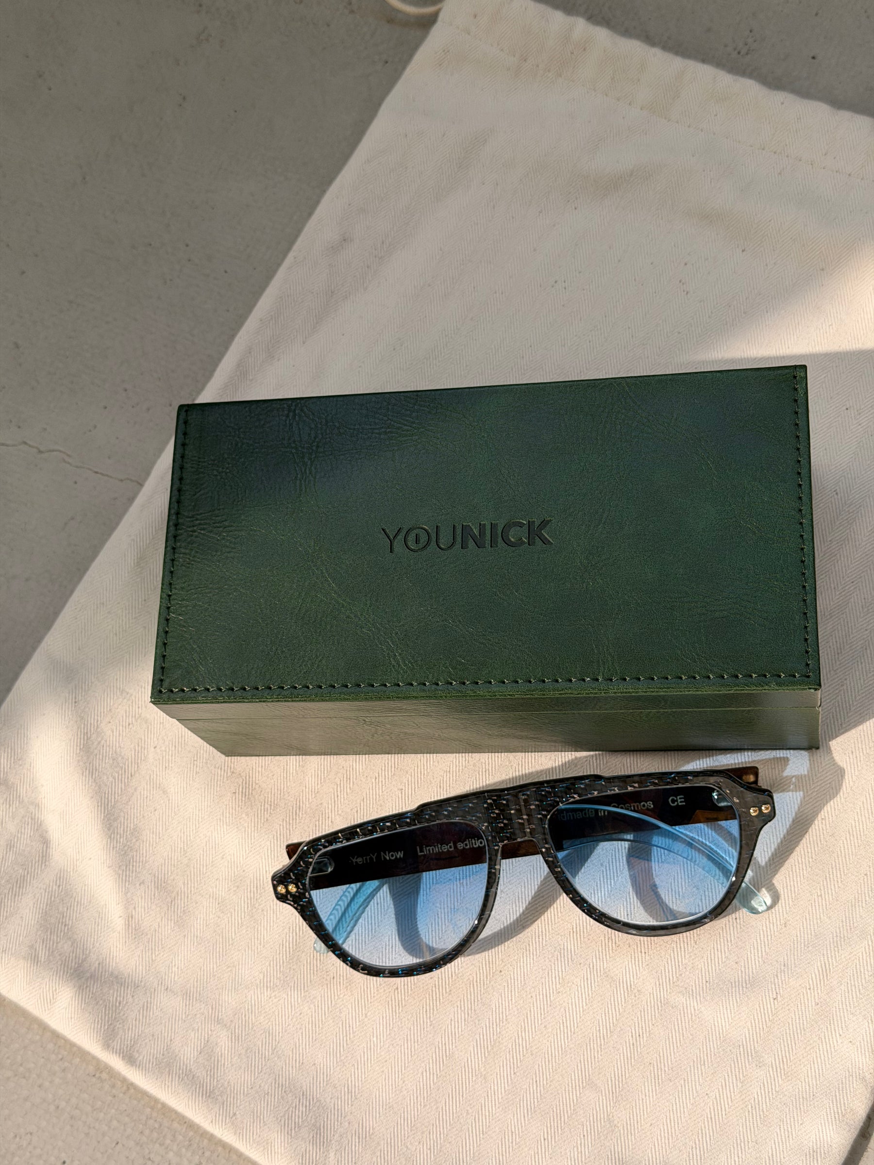 Green YouNick box and YerryNow One eyewear on a linen pouch